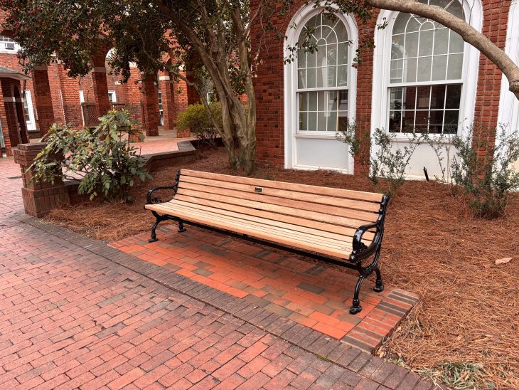 A memorial bench dedicated to Angel Patrick outside of the Carlton Building on the Elon University campus.