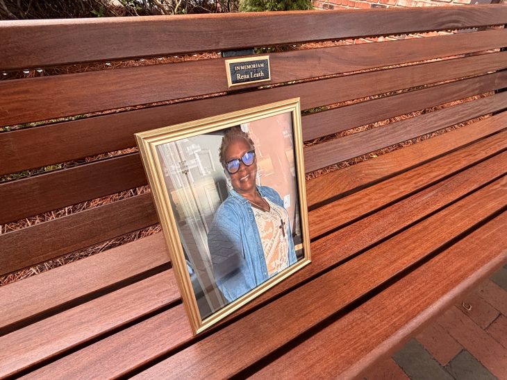 A photo of Rena Leath sits on her memorial bench between Story and Moffitt Halls.