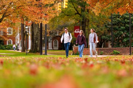 Three students walking on Elon University's campus.