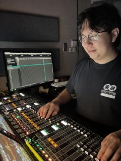 Brandon Cericola controlling audio at his console station.