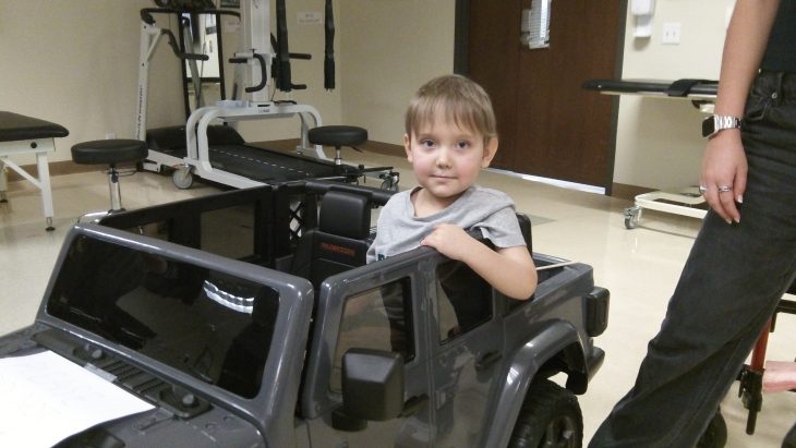 Go Baby Go participant trying out a kids electric ride-on car during an evaluation