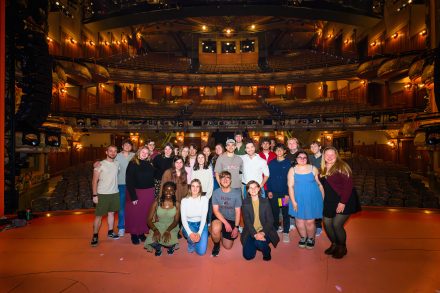 Students with alumni taking photo on "Aladdin" Broadway stage 