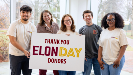 group of students and President Book holding a sign that says Thank You Elon Day Donors