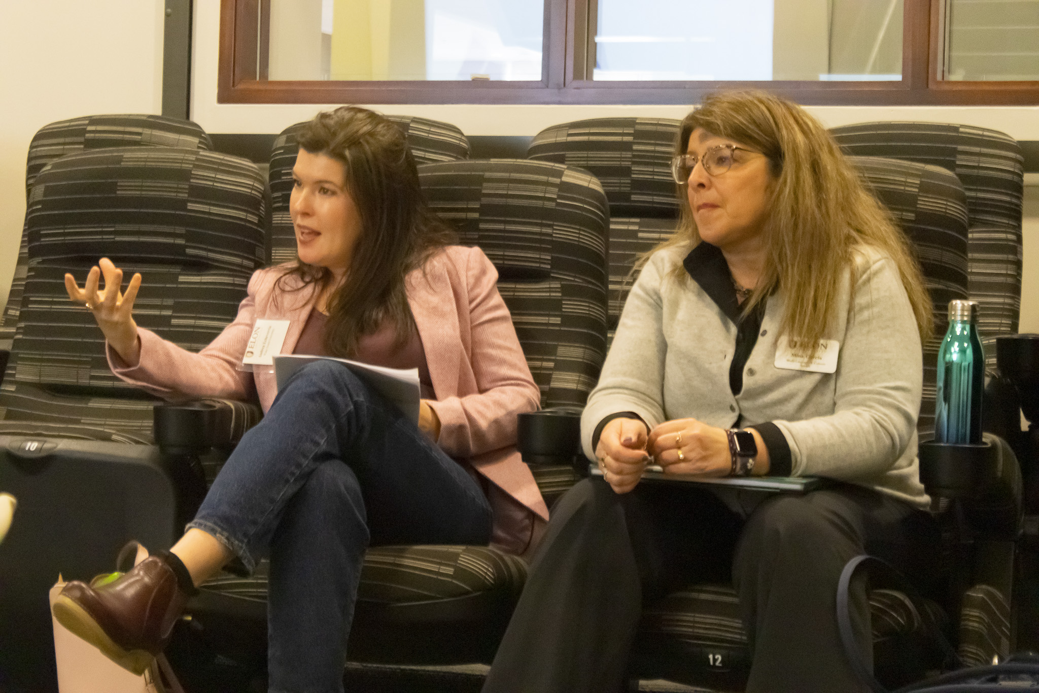 Two women sitting side-by-side in a discussion.