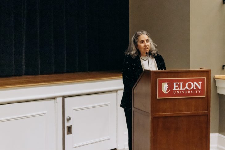 Women at podium delivering a presentation.