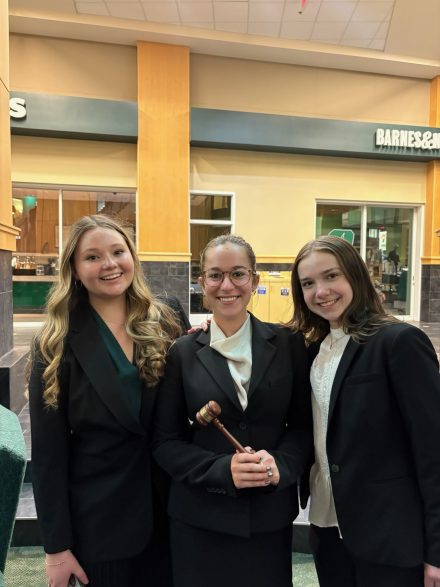 Three females posing for a photo after winning at the Regional competition. Girl is the middle is holding a gavel. 