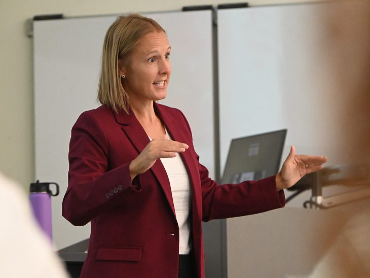 Lindsay Pieper, assistant professor of sport management, chats with students during class.