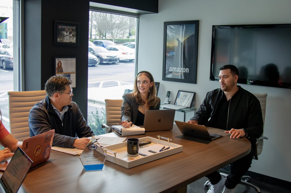 A group of people seated around a conference room table.