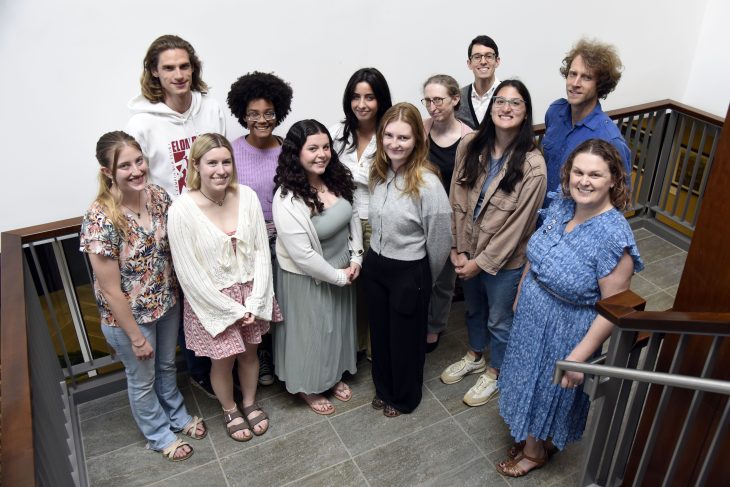 Several of the ���ϲ����� students who completed the Peace Corps Prep Program in 2025-26 pose with faculty mentors, including program director Jennider Eidum (far right), on a staircase landing of the Toshio Sato Commons on April 30, 2026.