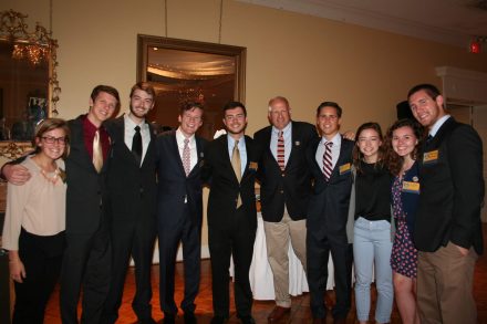 Jensen Roll '16, dressed in a dark suit, smiles alongside other members of the 2014 SOCAP Conference.