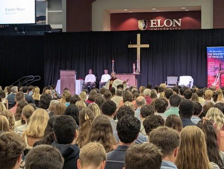 Priest speaking to a large crowd