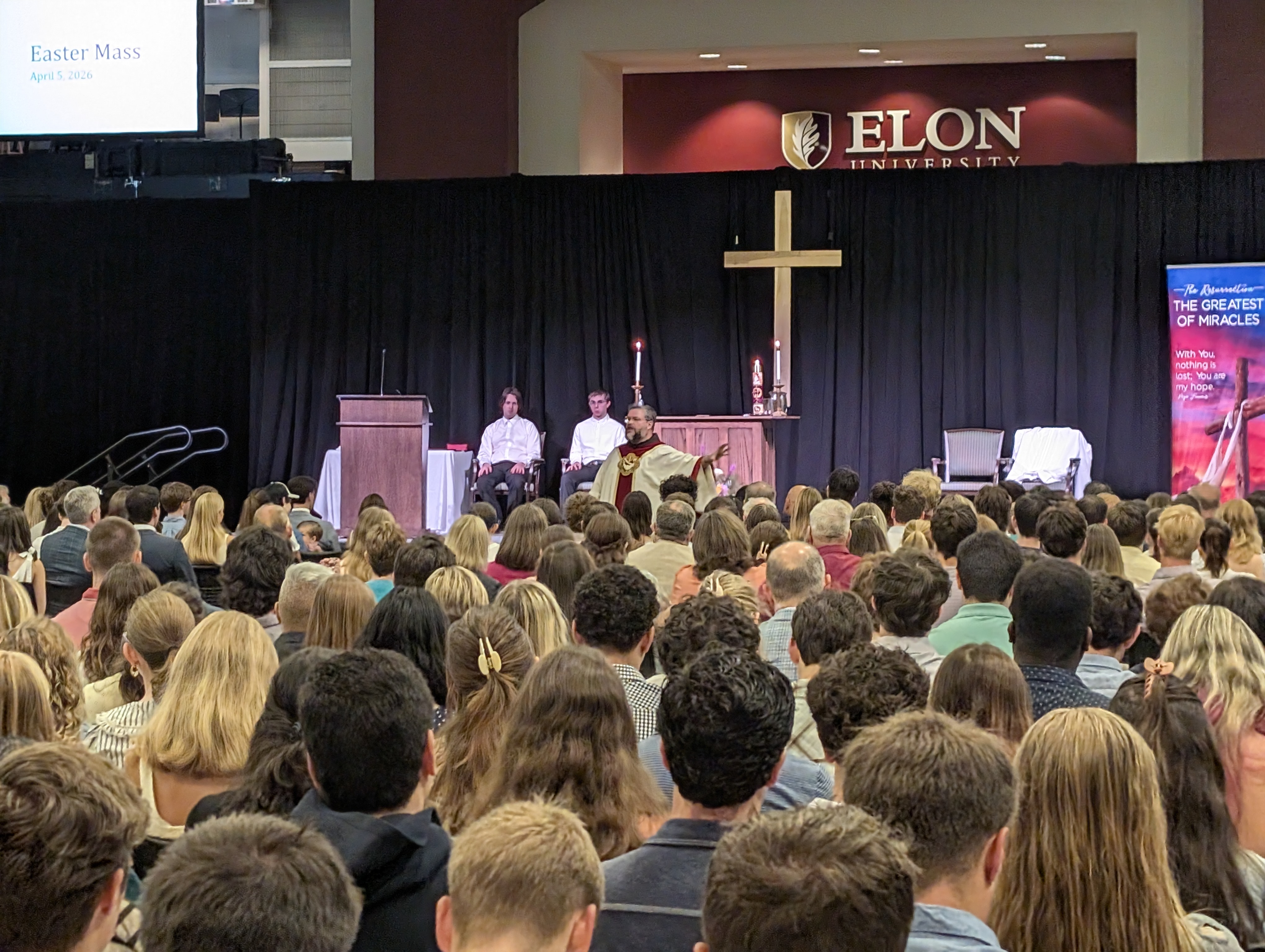 Priest speaking to a large crowd