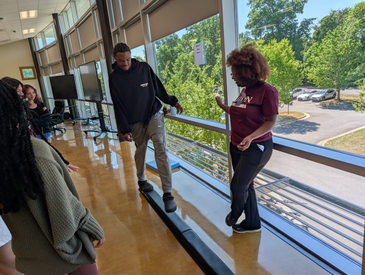 A student trying to walk on a narrow beam