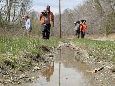 A group of people participate in cleaning up a waterway