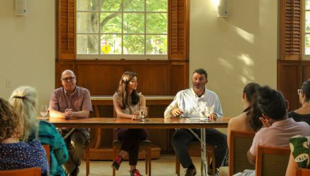 Three panelists sitting at a table.