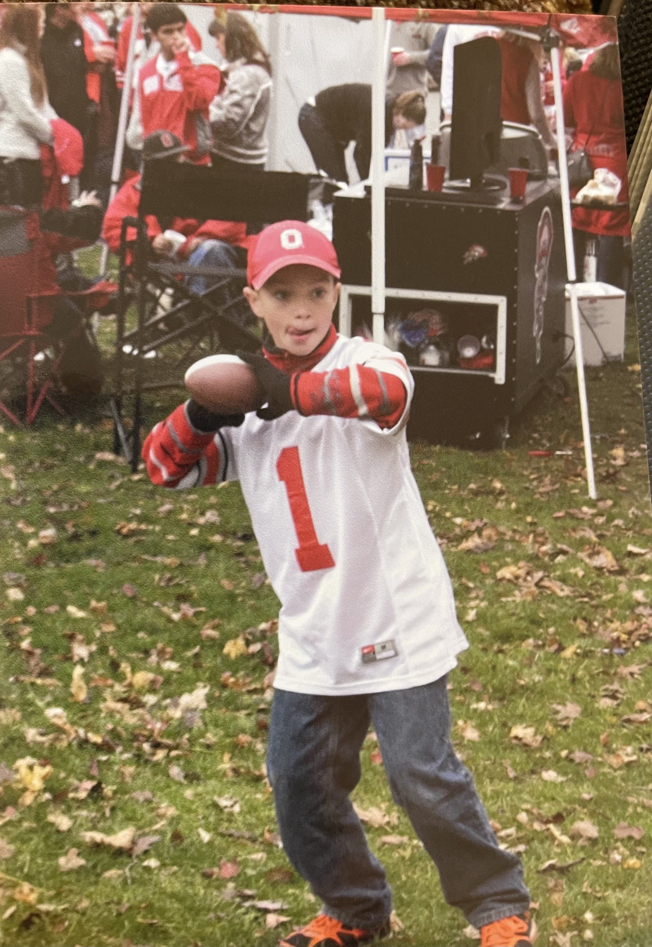 Jonathan Weaver wearing an Ohio State University hat and jersey at an Ohio State University football tailgate when he was younger.