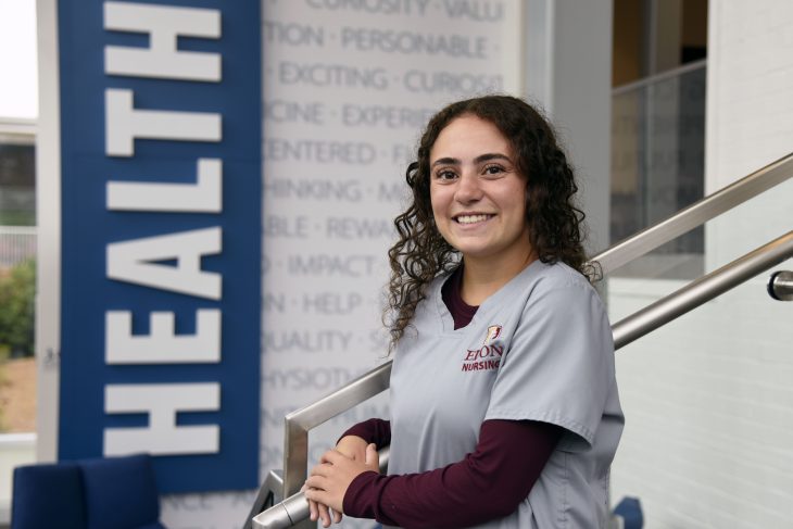 Allie Schult ’26, a nursing student in Elon University's Class of 2026, poses in her nursing scrubs inside the Francis Center, home to the School of Health Sciences. Schult will begin her nursing career at Children's Healthcare of Atlanta following graduation.