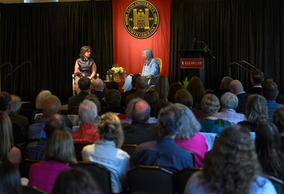 Jodi Kantor and Catherine Dunham on a stage. The backs of audience members' heads are visible in the foreground.