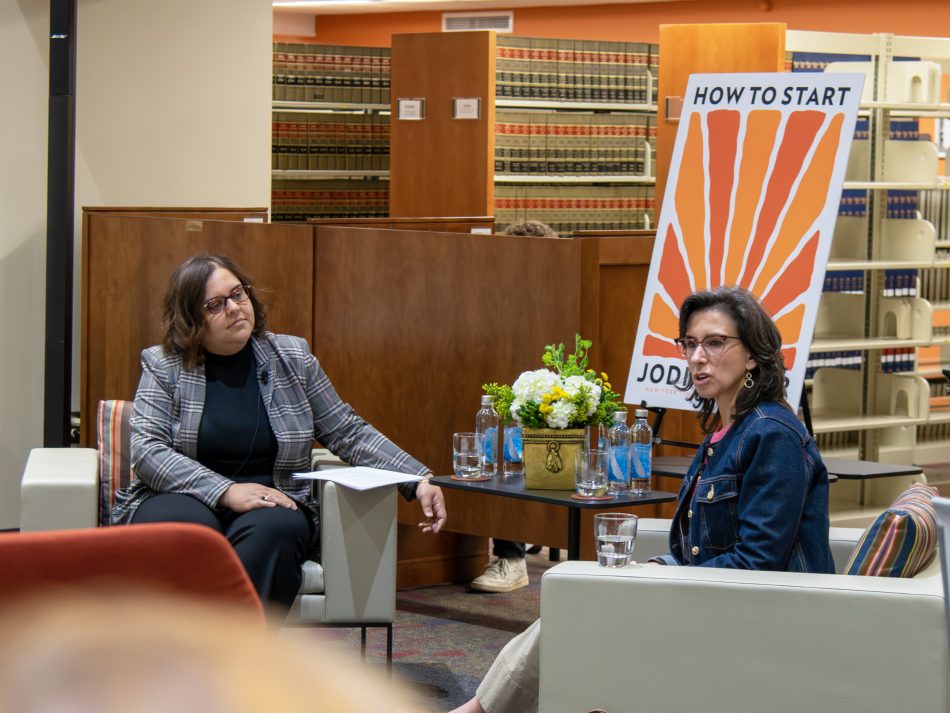 Jodi Kantor speaks in front of a poster of her book "How To Start" with Associate Dean Anu Pal in the Elon Law Library.