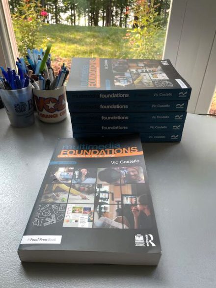 “Multimedia Foundations: Core Concepts for Digital Design" books are placed near a window.