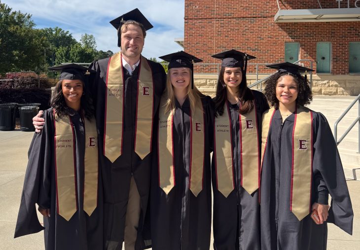 Simrin Carlsen G’26 and four fellow Elon student-athletes pose in graduation caps and gowns