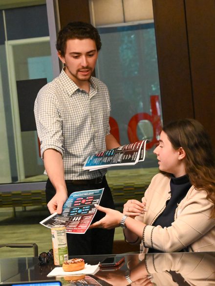 Jack Sindone '26 hands a paper to classmate