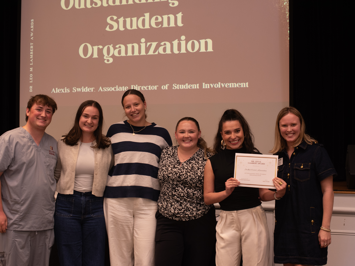 Members of a student organization pose with their award on stage after being recognized as an Outstanding Student Organization at the Dr. Leo M. Lambert Awards.
