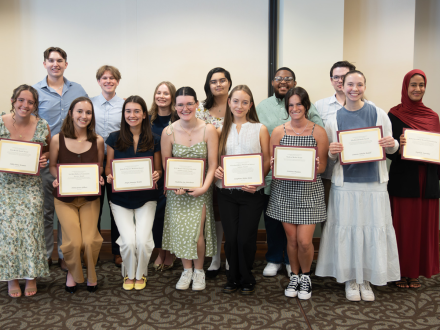 Students pose with their certificates after being recognized for academic excellence and leadership across campus.