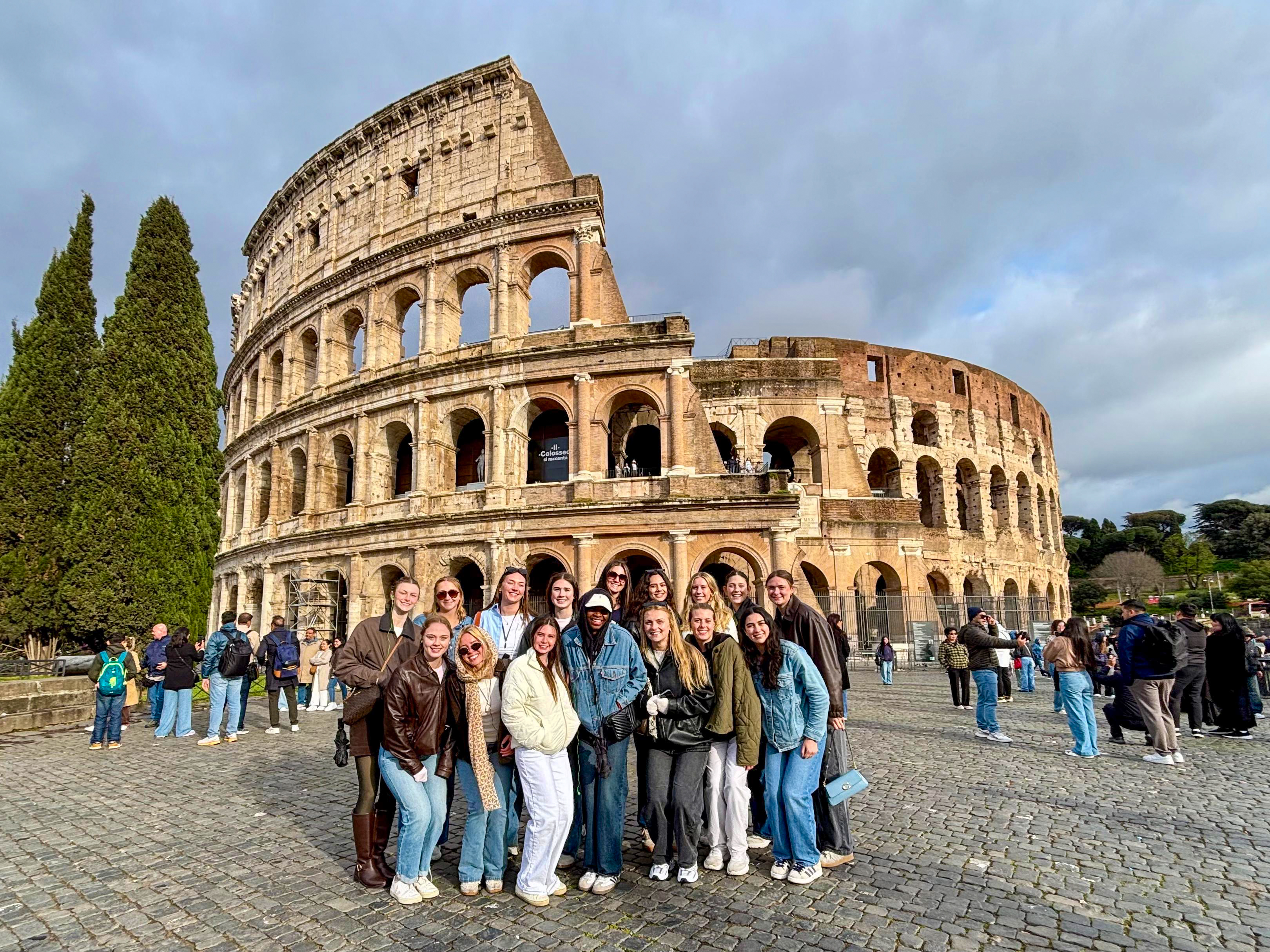 Simrin Carlsen G’26 poses with a group of ���ϲ����� students in front of the Colosseum in Rome.