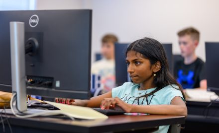 Trisha Anna working on an activity on the computer at AI Play.