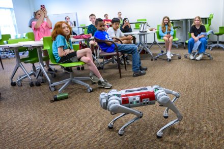 Middle school students at AI Play camp watch a demonstration of robot dog. 