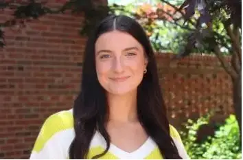 Headshot of Alyssa Carny with bricks in the background