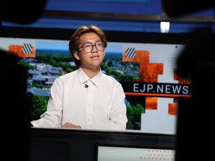 An EJP student sits at an anchor desk