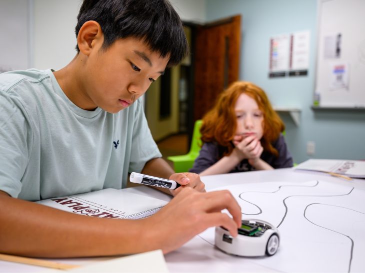 Middle school students participating in AI Play experiment with robot.