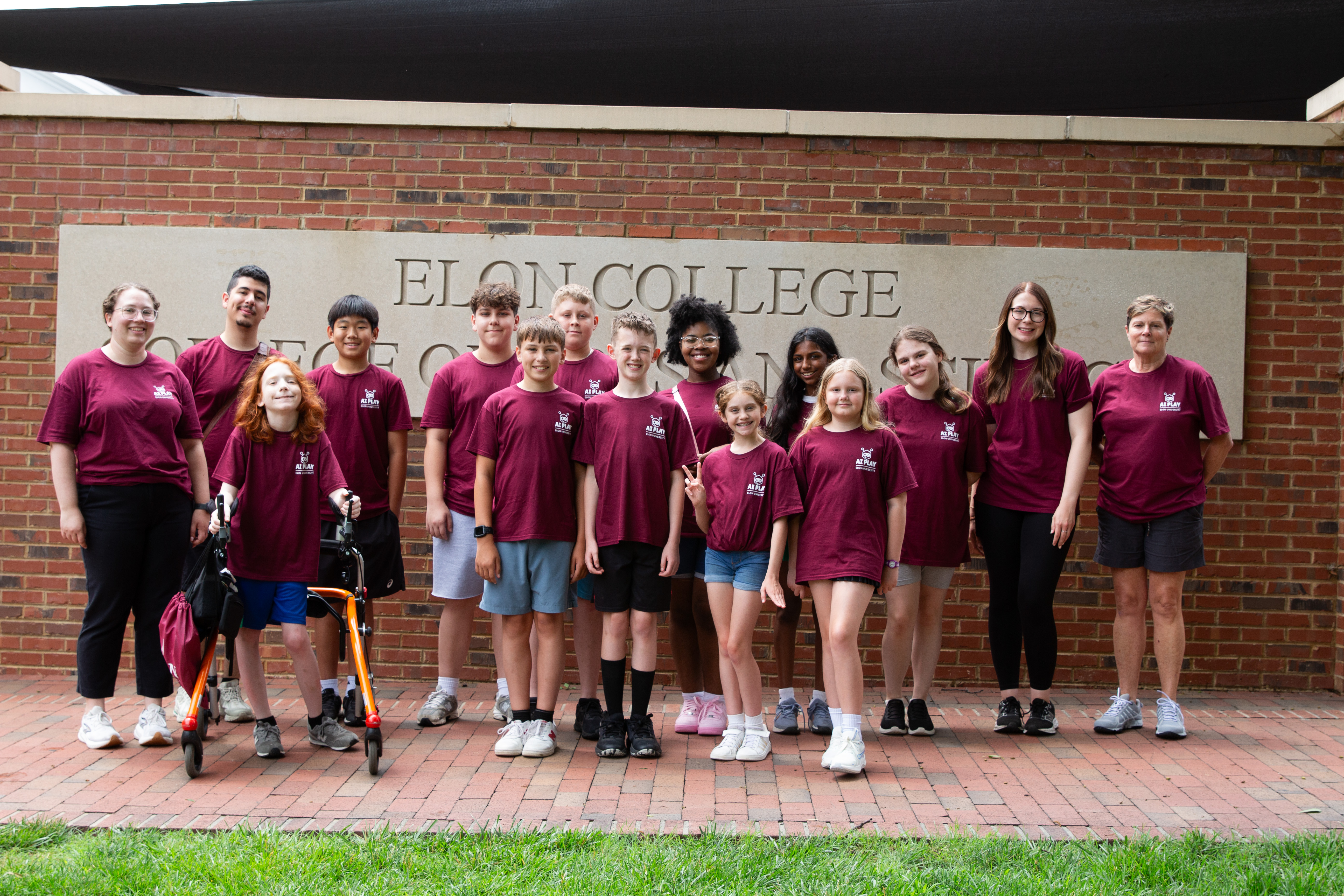 AI Play students, director and volunteers stand for a group photo outside. 