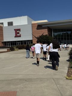 A group of students walks toward the Schar Center entrance during a guided campus visit.