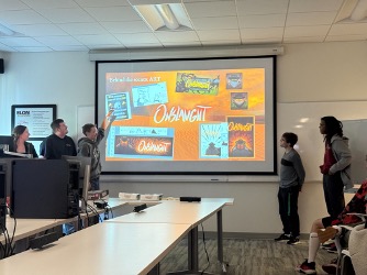 The InDecision Studio team standing in front of screen presenting to class.