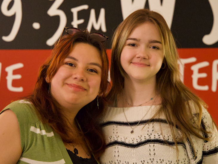 Maria Lagunes Flores and Rylin Kent, both class of 2029, posing together in front of a 89.3 FM WSB radio station banner.