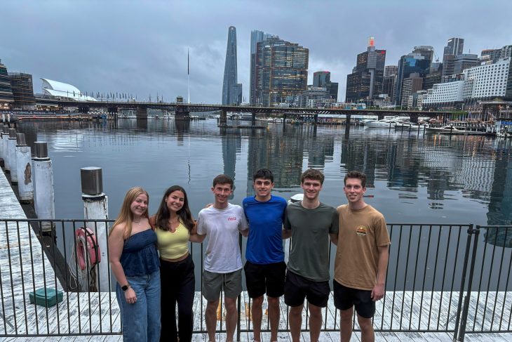 Six Business Fellows stand together along a waterfront with the Sydney skyline and harbor in the background during the Asia Pacific semester experience.