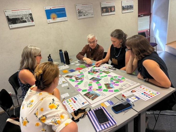 A group of people around a table playing a board game