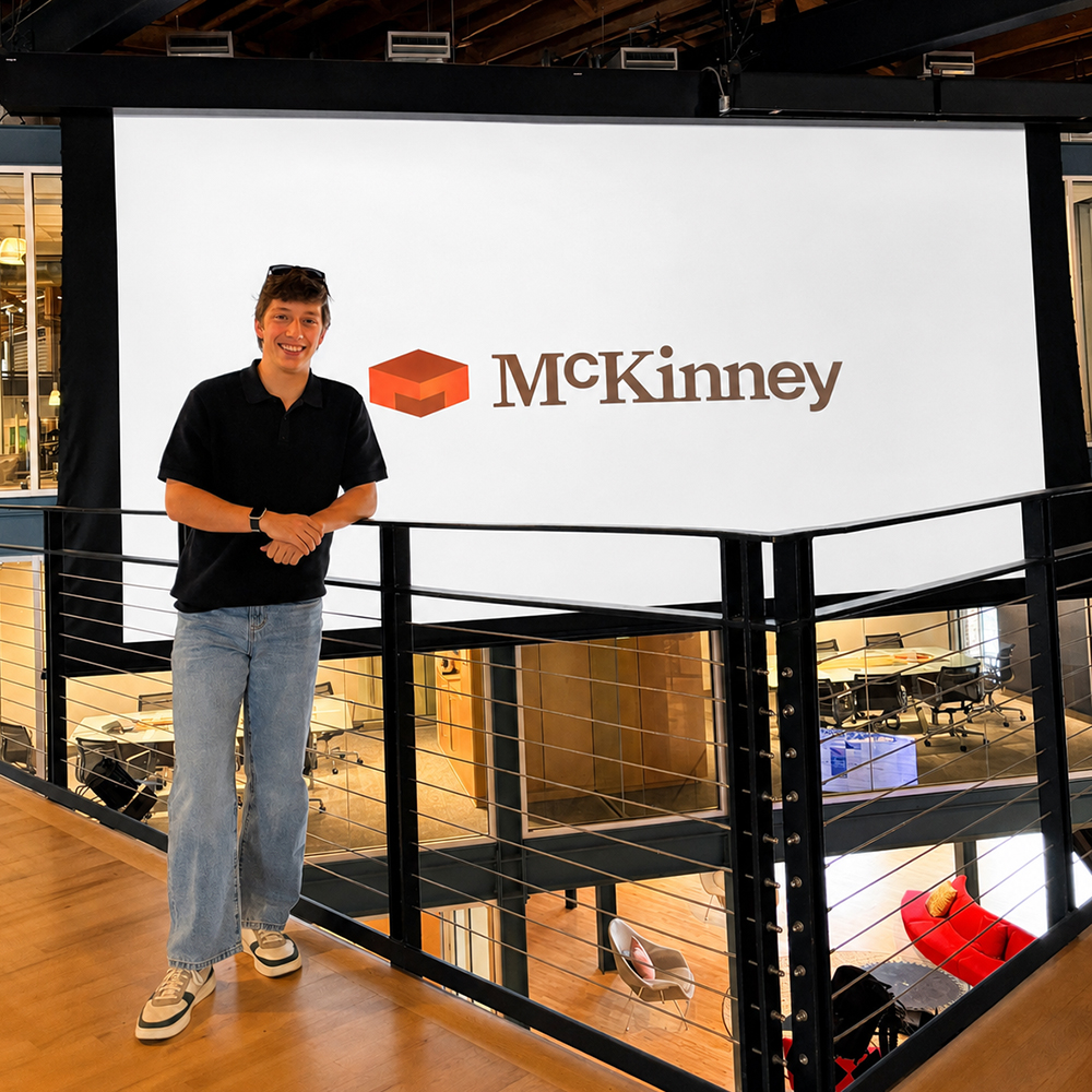Elon student stand in McKinney's contemporary office space.