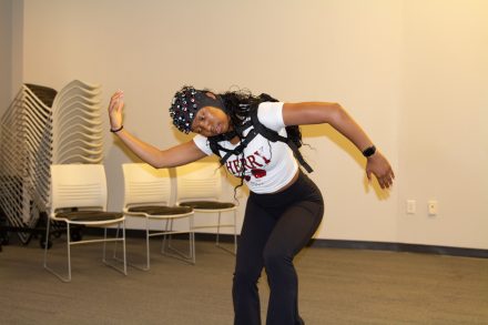 Student wearing a portable fNIRS device on her head while dancing.