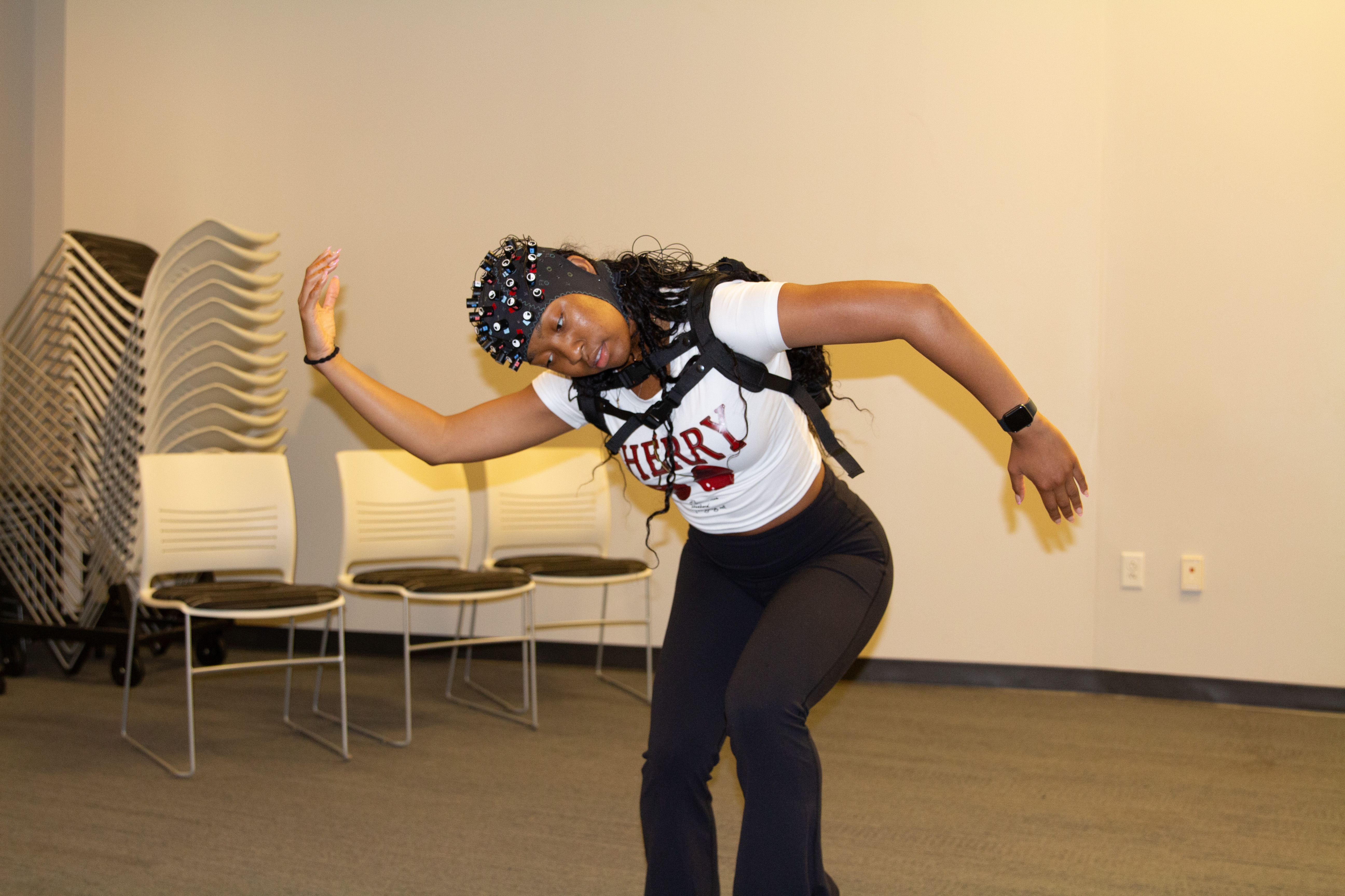 Student wearing a portable fNIRS device on her head while dancing.
