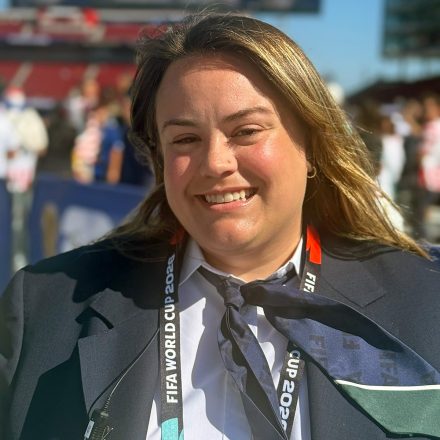 Cirby smiles in formal FIFA attire.