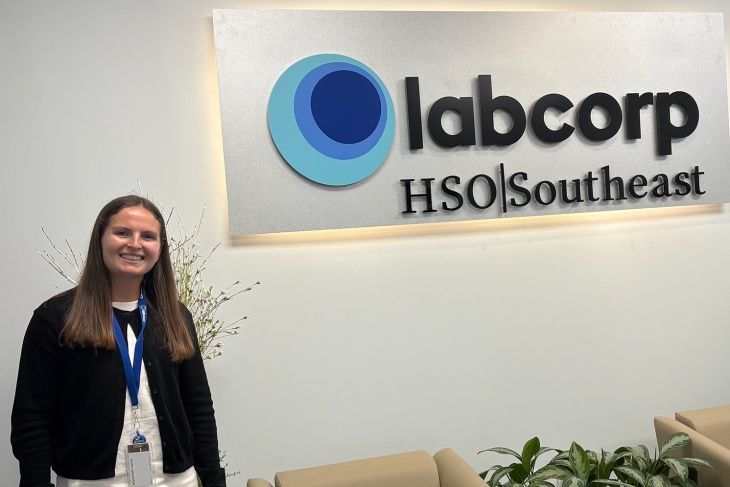 Jordan Green stands beside a large Labcorp HSO Southeast sign inside the company’s Tampa office.