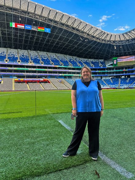 Cirby stands on grass inside a massive stadium