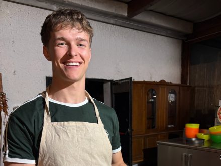 A smiling person wearing an apron labeled “Antico Frantoio Sorrento"