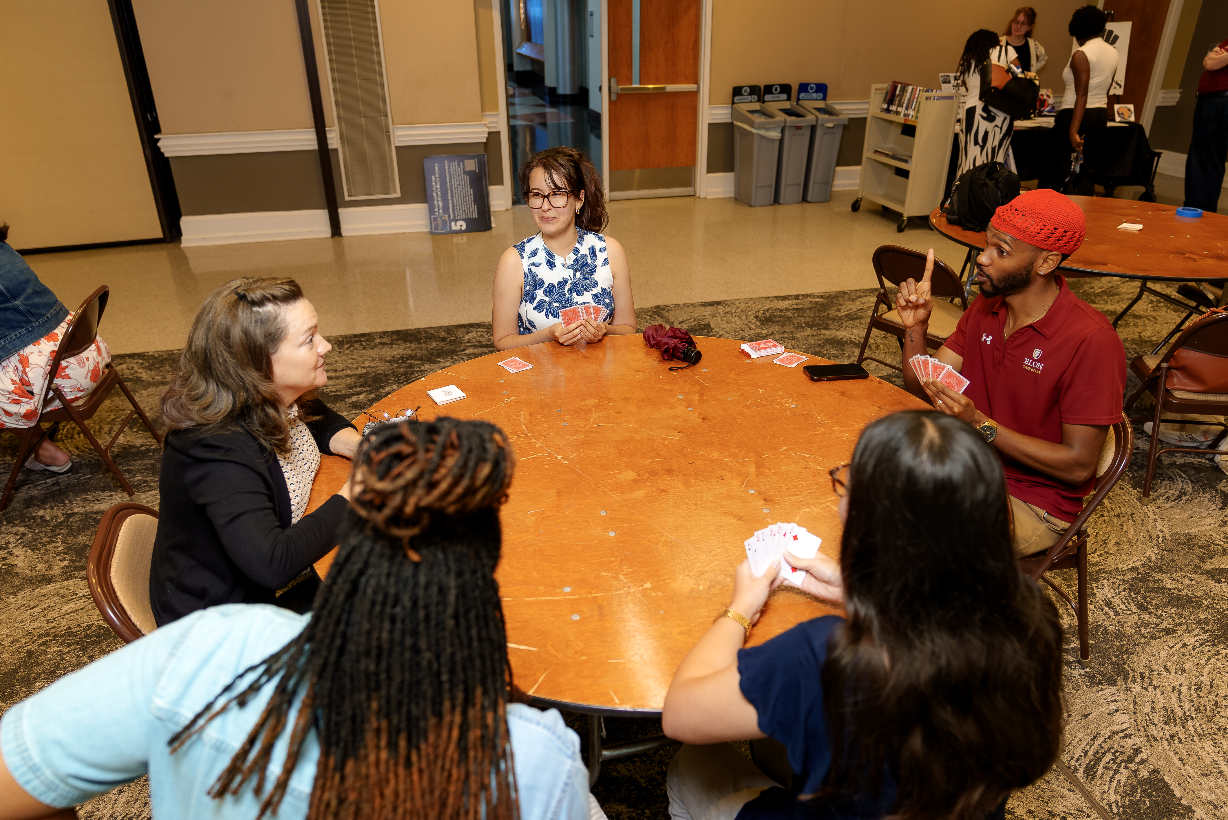 Participants play a game of Spades around a table during a Juneteenth celebration, encouraging conversation, friendly competition and community building.