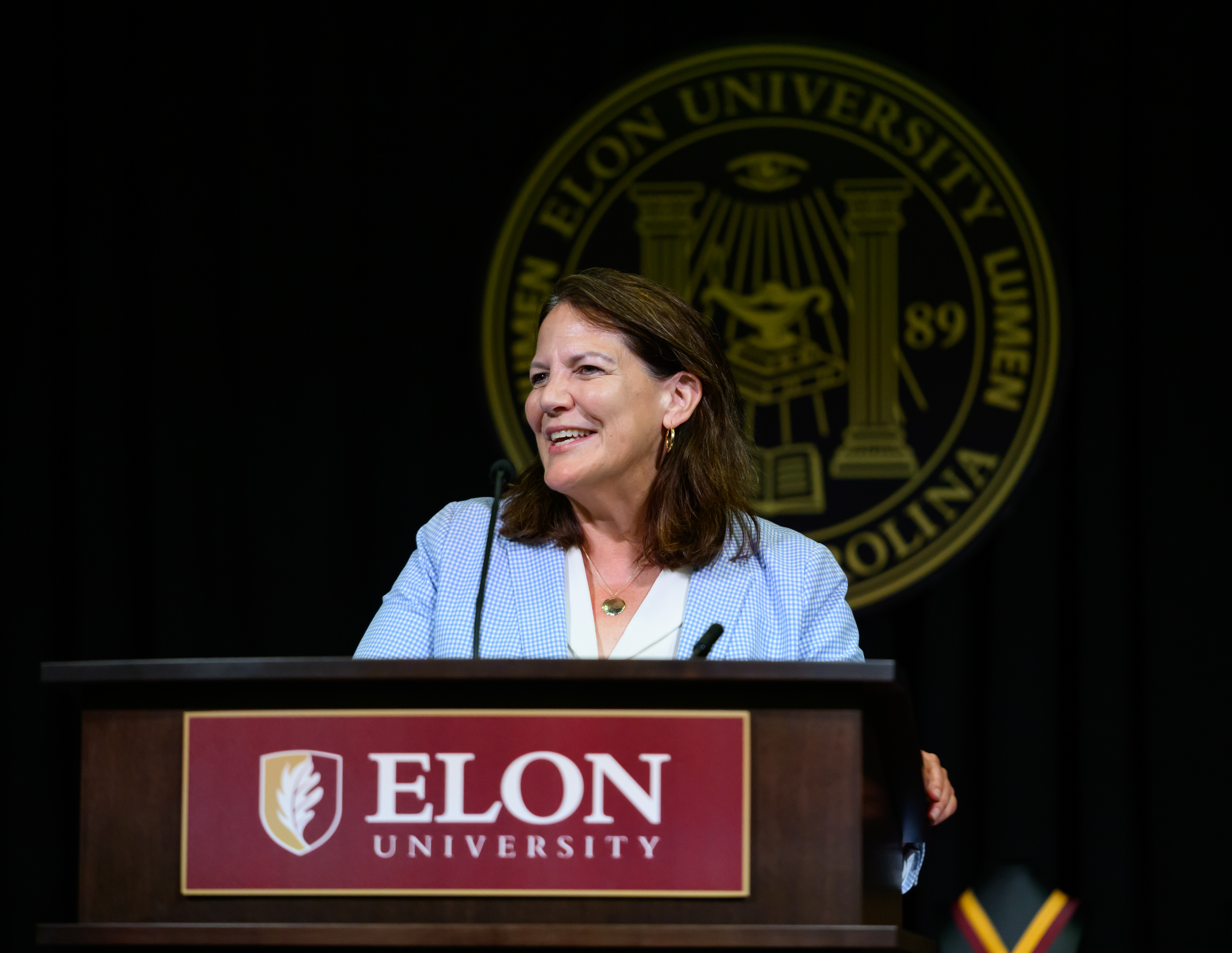  Elon University President Connie Ledoux Book smiles while speaking at a podium during the university’s Opening Day ceremony.