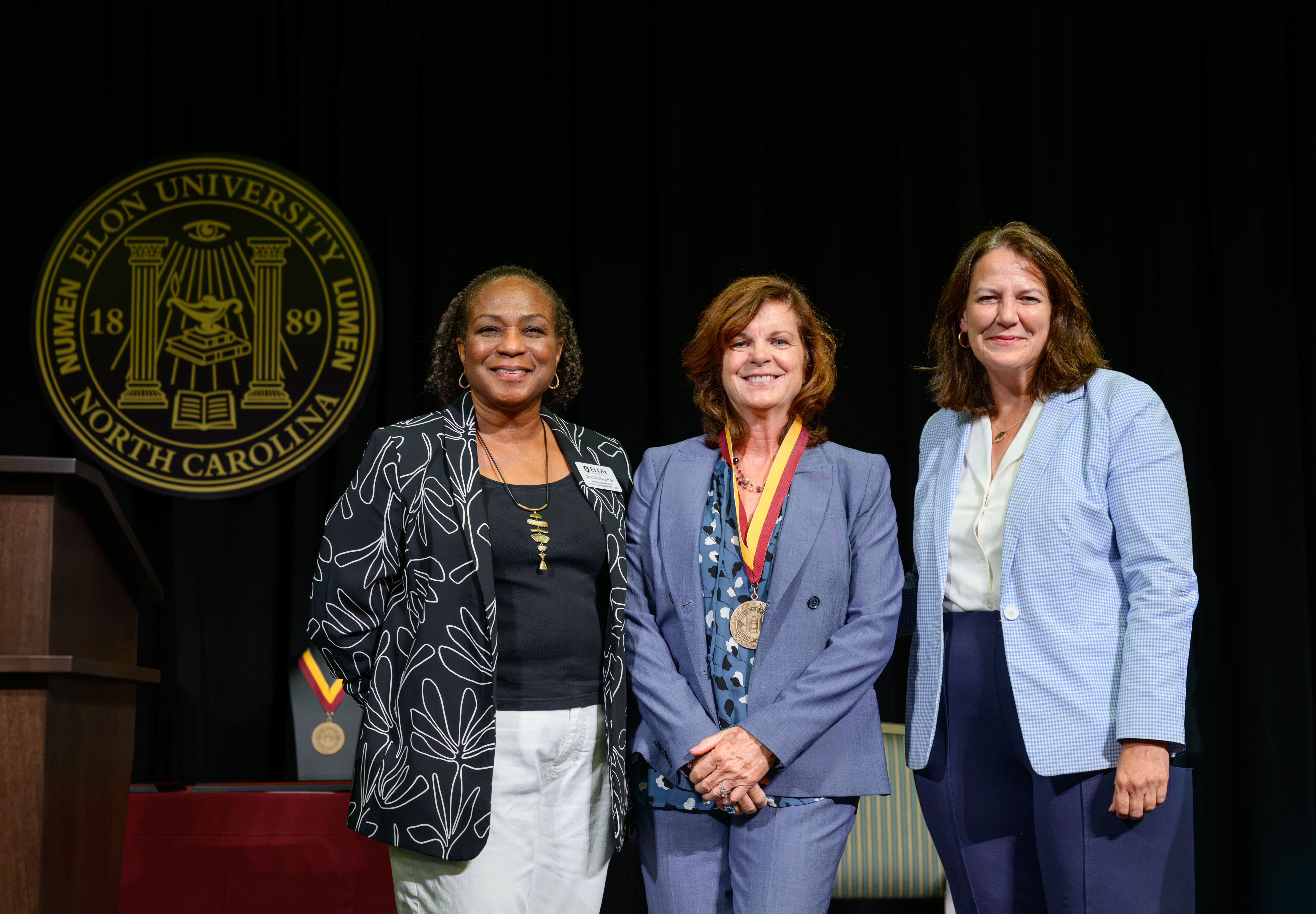  Mary Thornton, center, wears the Elon Medallion while posing with Janet Williams and Elon President Connie Ledoux Book on stage.